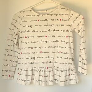 Long sleeve white shirt with ruffle bottom with button neck and heart open neck